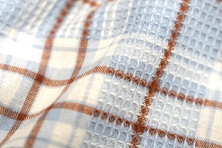 Close-up view of a textured performance fabric showing its woven stretch pattern.