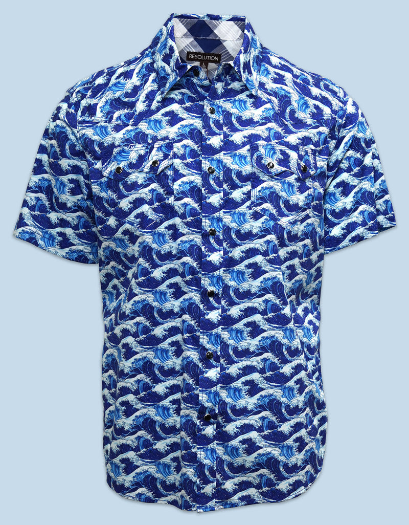 A short-sleeve button-down performance shirt featuring a vibrant blue and white ocean wave print against a light blue background. This lightweight top is tailored with a modern fit designed for active movement, casual styling, and everyday versatility.